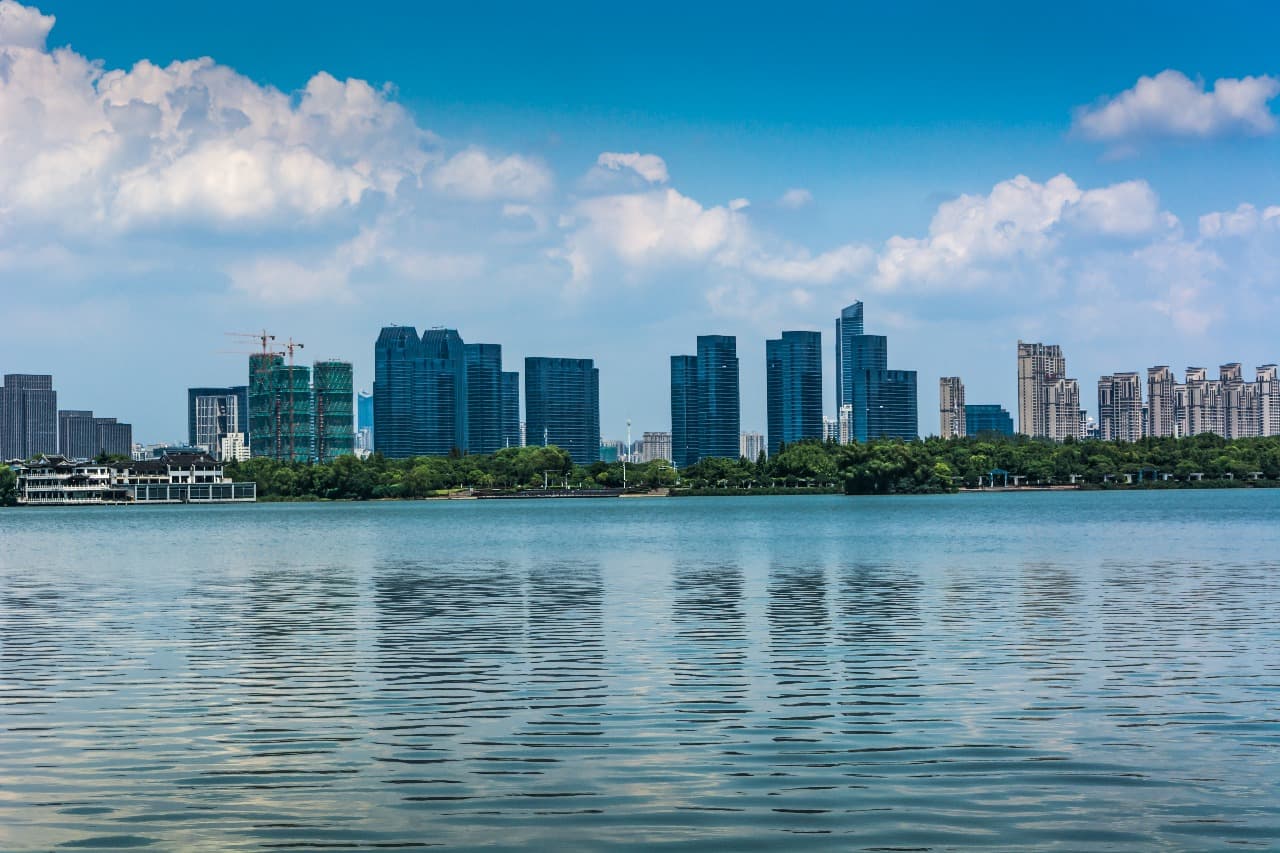 A wide-angle shot from a balcony overlooking a lush, green cityscape with a river.